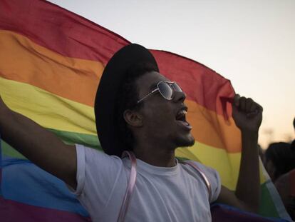 Homem levanta a bandeira LGBTQ durante o Rock in Rio, no último domingo.