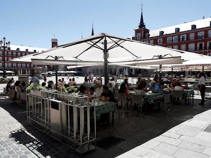 Varios turistas en la terraza de un restaurante de la plaza Mayor de Madrid, este sábado.