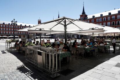 Varios turistas en la terraza de un restaurante de la plaza Mayor de Madrid, este sábado.