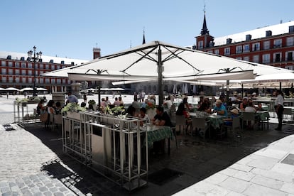 Varios turistas en la terraza de un restaurante de la plaza Mayor de Madrid, este sábado.