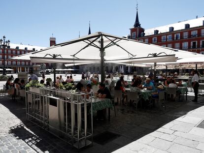 Varios turistas en la terraza de un restaurante de la plaza Mayor de Madrid, este sábado.