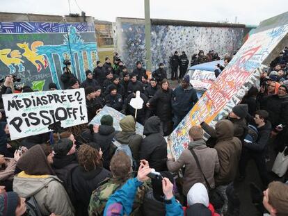 Manifestantes paralizan el derribo, ya comenzado, de un tramo del Muro de Berl&iacute;n e intentan recolocar una r&eacute;plica exacta de la parte demolida en el hueco abierto por los obreros. 