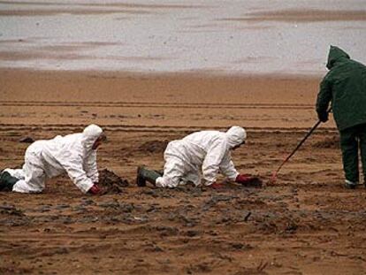 Varios trabajadores se afanaban ayer en la recogida de chapapote en la playa de Sopelana (Vizcaya).