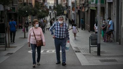 Dues persones passegen per un carrer de l'Hospitalet de Llobregat.