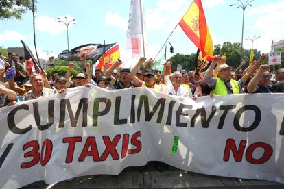 Los manifestantes sostienen una pancarta que pide el cumplimiento de la ley respecto a los VTC, en la manifestación de Madrid.