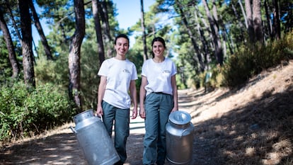 Paula López Montero y María Luz Villegas con las cántaras que utilizan para trasportar la leche de cabra.