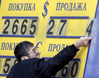 Un trabajador de una oficina de cambio coloca unas placas para formar las cifras del cambio dólar-rublo en Moscú, Rusia. EFE/Archivo