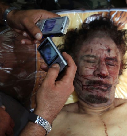 Varias personas toman imágenes del cuerpo de Gadafi, a su llegada a Misrata.