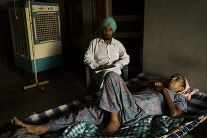 Mohinder Kaur, de 48 años, cuyas dos hermanas han padecido también cáncer y que se recupera de su segundo tumor, descansando en casa junto a su marido. Mari Mustafa, Punyab, India. 