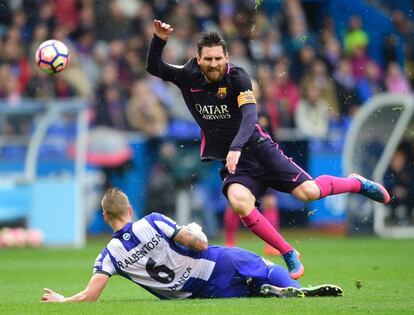 Lionel Messi, del Barcelona, antes de caer al suelo por la entrada del jugador del Deportivo Raúl Albentosa.

