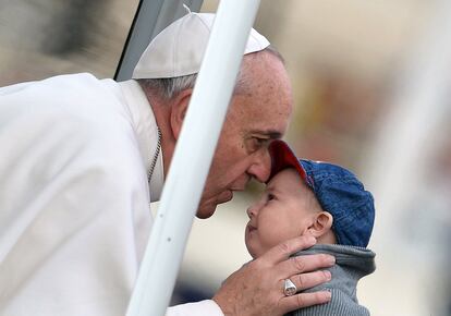 Papa Francisco besa a un niño a su llegada en la plaza de San Pedro en el Vaticano.