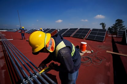 Trabajadores instalan paneles solares en una azotea en Ciudad de México, en 2022.