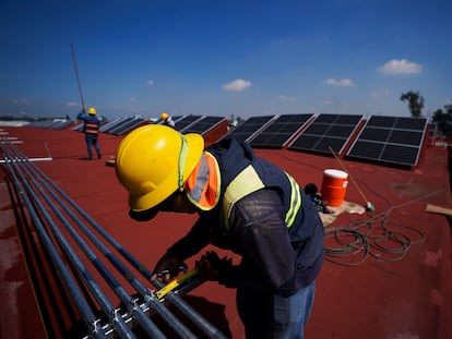 Trabajadores instalan paneles solares en una azotea en Ciudad de México, en 2022.