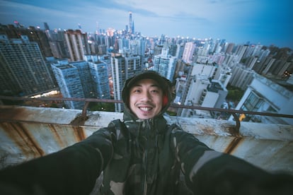 Retrato de un hombre en una azotea de Shanghai, China, usando la cámara gran angular de su teléfono móvil.