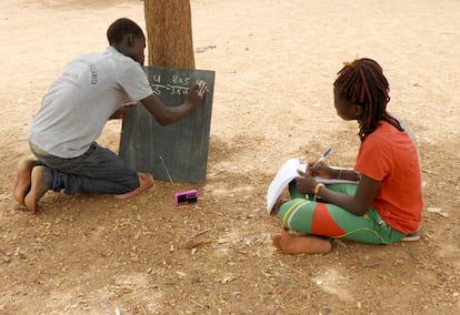 Two teenagers study over the radio in Burkina Faso, as an alternative when in-person classes are not possible.