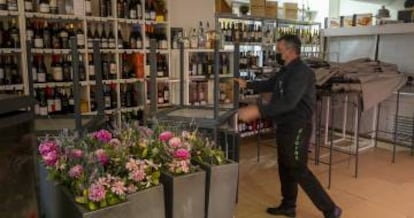 Un camarero guarda las mesas en el interior de un bar en Sevilla.