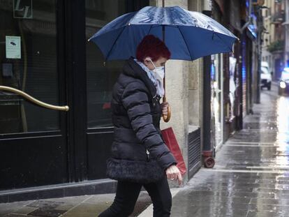 Una mujer con mascarilla camina por un desierto Casco Viejo de Pamplona.