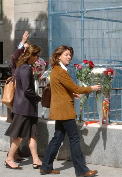 Varias personas colocan ramos de flores junto al lugar en el que se encontraba la estatua ecuestre de Franco.