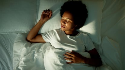Una mujer durmiendo en la cama plácidamente.