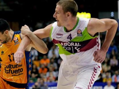 Rafa Martínez, a la izquierda, trata de escapar de la marca de Colton Iverson, de Laboral Kutxa, en el partido diputado este viernes en Valencia. 