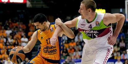 Rafa Martínez, a la izquierda, trata de escapar de la marca de Colton Iverson, de Laboral Kutxa, en el partido diputado este viernes en Valencia.