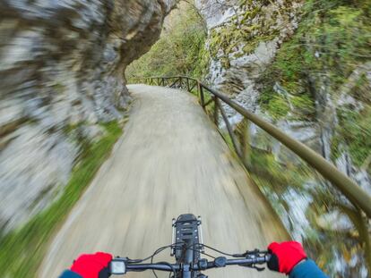 Un ciclista pedalea por un camino en plena naturaleza en Asturias.