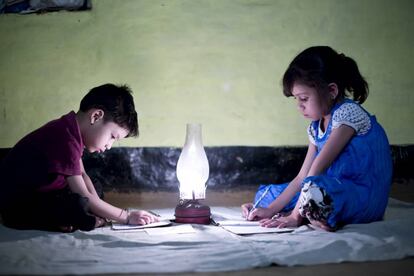 Dos niños leen en la penumbra. 