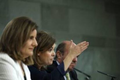 La ministra de Empleo, Fátima Báñez (i); la vicepresidenta del Gobierno, Soraya Sáenz de Santamaría (c), y el ministro de Economía, Luis de Guindos (d), durante la rueda de prensa posterior a la reunión del Consejo de Ministros de hoy, en la que el Gobierno ha analizado el cumplimiento del Plan Nacional de Reformas y el avance de nuevas reformas legislativas, dos de las cuales se han aprobado este mismo viernes: el anteproyecto de ley de colegios y servicios profesionales y el informe sobre la reforma laboral.