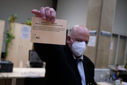 Una de las personas encargadas del recuento en el colegio electoral del Ayuntamiento de Don Benito sostiene una papeleta con el no.