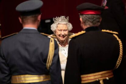 La reina, muy sonriente ante dos militares.