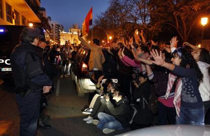 Estudiantes con las manos levantadas frente a los agentes que custodian el edificio donde reside Rita Barber&aacute;.