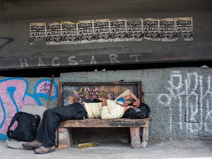 Un hombre duerme en un banco debajo de un puente, en Bogotá, el 3 de julio de 2020.