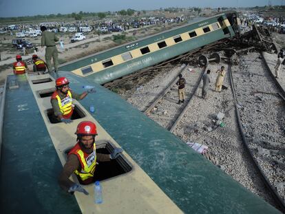 Pakistani security and rescue officials inspect the derailed carriages of a passenger train in Sanghar, near Nawabshah, Pakistan, 06 August 2023.