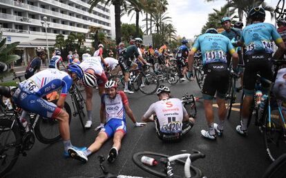 Thibaut Pinot (a la izquierda), ciclista del equipo Groupama-FDJ, yace en el suelo tras una caída.