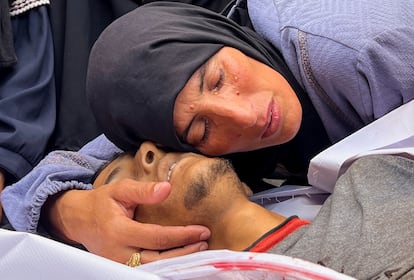 La madre de Hesham Ifsifis, quien murió en un ataque israelí mientras buscaba ayuda cerca de un punto de distribución, según los médicos, llora junto a su cuerpo en el hospital Nasser en Jan Yunis, al sur de la Franja, este sábado. 