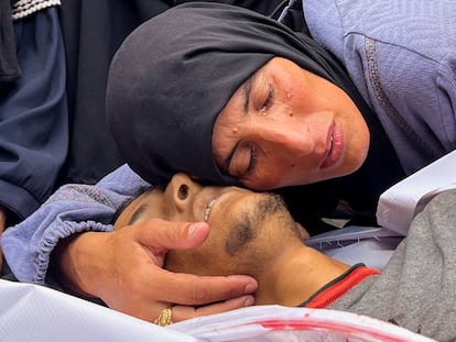 La madre de Hesham Ifsifis, quien murió en un ataque israelí mientras buscaba ayuda cerca de un punto de distribución, según los médicos, llora junto a su cuerpo en el hospital Nasser en Jan Yunis, al sur de la Franja, este sábado.