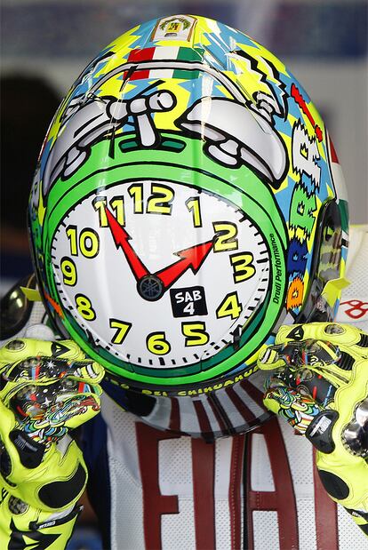 Valentino Rossi se pone el casco, de colores llmativos y en el que aparece seriagrafiado un reloj, durante la sesión de entrenamientos libres de Misano.