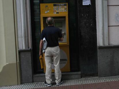 Un cliente saca dinero en un cajero de CaixaBank