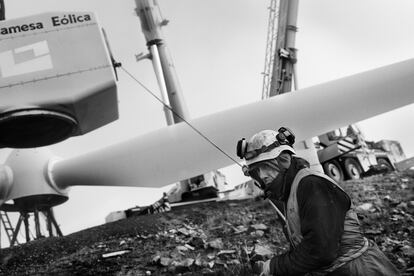 Un operario del parque eólico de Aldeavieja (Ávila), orienta con una cuerda el rotor de un aerogenerador, en octubre de 2024.