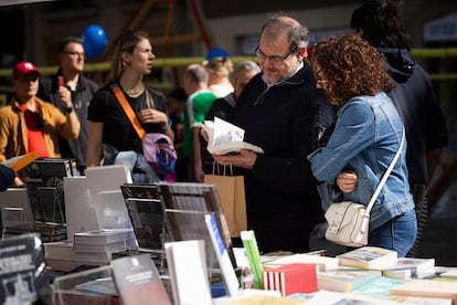 La gente se reúne en los puestos de la feria de Sant Jordi, en Barcelona, para hojear libros.