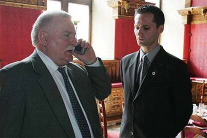 Lech Walesa habla por teléfono en presencia de su hijo, Jaroslaw.