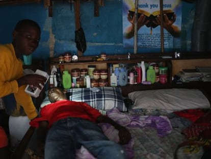 Um menino prepara o pai, com suspeita de ebola, para ser levado a um centro de isolamento.