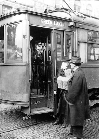 Un conductor de tranvía impide el acceso a un ciudadano sin mascarilla en Seattle, Washington, en diciembre de 1918. Las precauciones en la ciudad durante la mal llamada gripe española incluyeron la obligatoriedad de llevar mascarillas en transporte público.