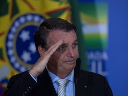 O presidente Bolsonaro faz uma saudação militar após sancionar a lei de autonomia do Banco Central.