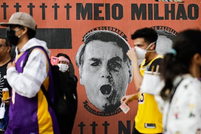 Manifestantes izquierdistas pasan, el sábado pasado en São Paulo, ante un mural que culpa al presidente Bolsonaro del medio millón de muertos por el covid-19.