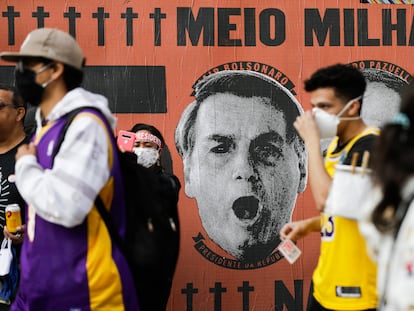 Manifestantes izquierdistas pasan, el sábado pasado en São Paulo, ante un mural que culpa al presidente Bolsonaro del medio millón de muertos por el covid-19.