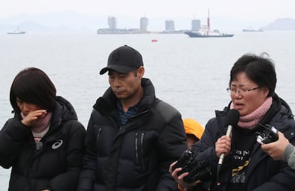 Algunos parientes de los desaparecidos tras el incidente hablan con los medios. Detrás, varios barcos trabajan en la operación de rescate de los restos de la embarcación.