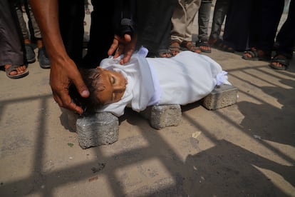 El cuerpo de Jamal al-Najjar, de cinco años, es depositado sobre ladrillos antes de la oración fúnebre tras morir de hambre en un hospital de Jan Yunis el martes.