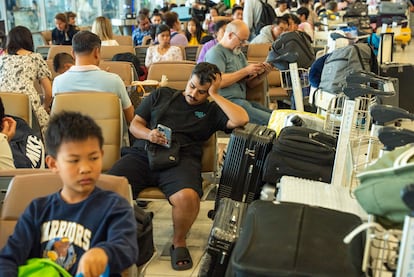 Decenas de pasajeros esperan en el aeropuerto de Suvarnabhumi en Bangkok (Tailandia), este viernes. 