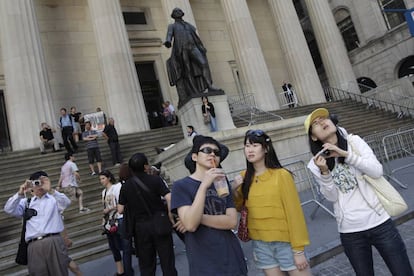 Grupo de turistas de China afuera de la Bolsa de Nueva York  y el Federal Hall National Memorial.